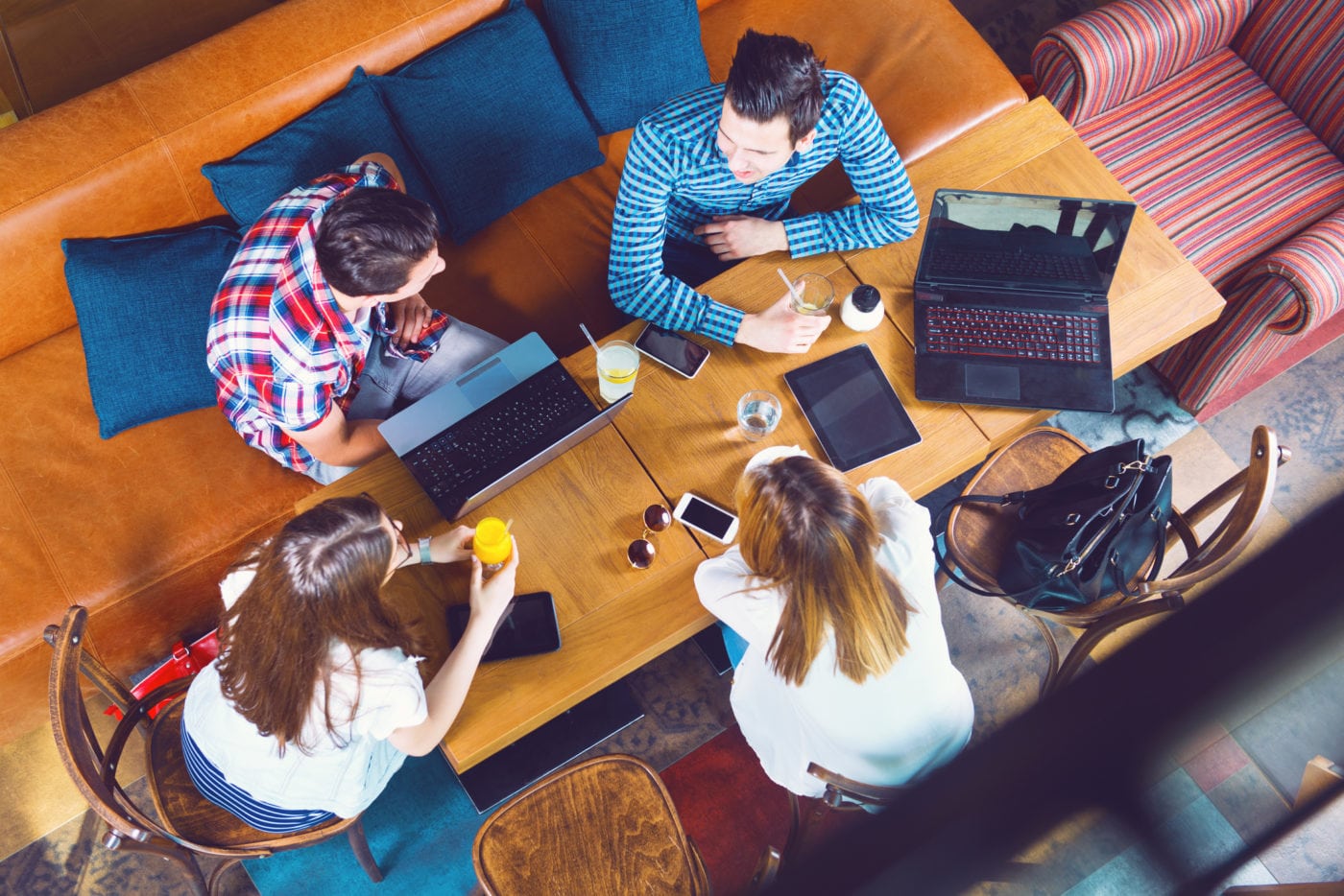 Group of young people sitting at a cafe, top view